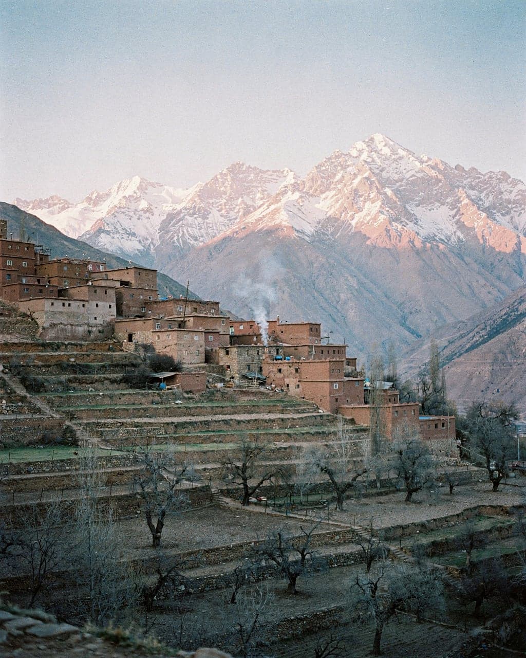An Atlas village of earth-coloured houses near Imlil below snow-capped peaks in early morning