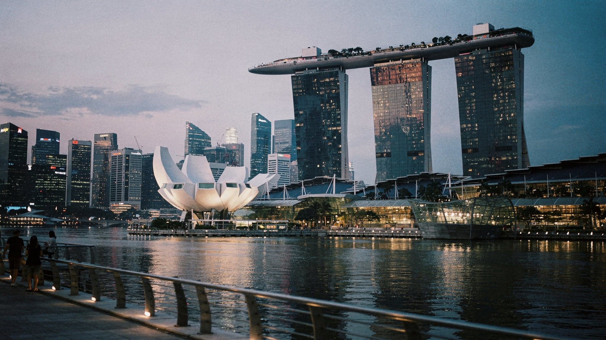 Marina Bay at blue hour, with the Marina Bay Sands towers and the lotus-shaped ArtScience Museum reflected in calm water