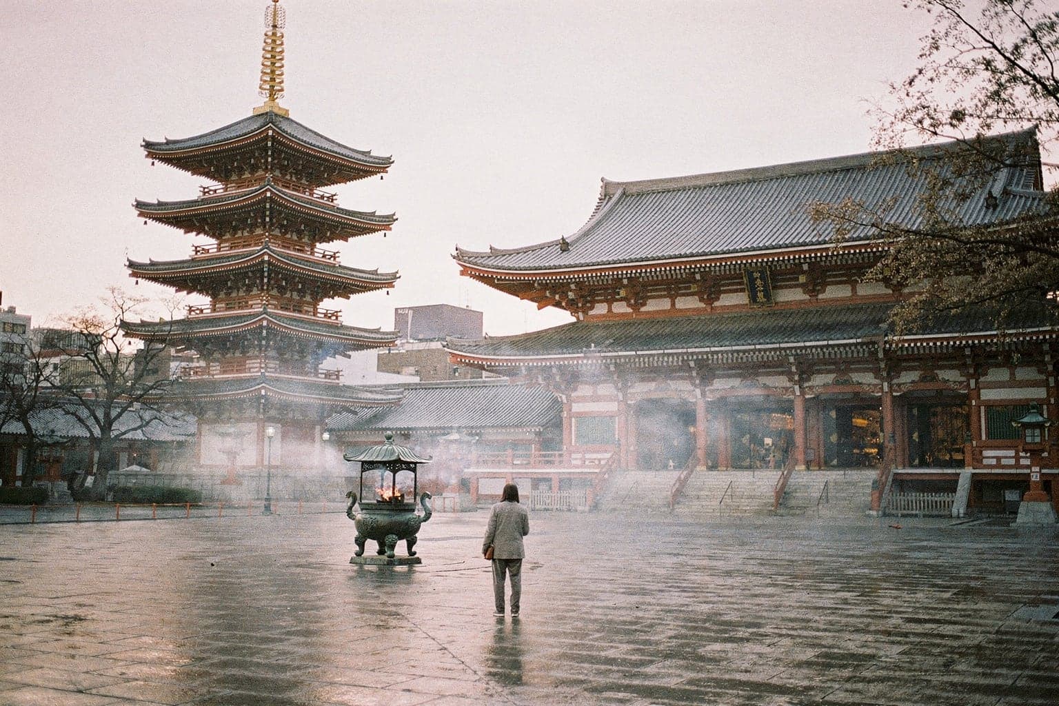 Sensō-ji's five-storey pagoda and main hall at dawn, incense smoke drifting across an empty stone courtyard